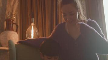 Woman joining boy doing homework in armchair video