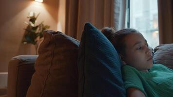 Girl lying on couch with screen light reflecting on eyes video