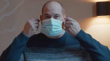 Man putting on face mask looking into camera lens video