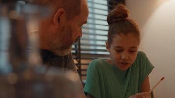 hombre ayudando a niña haciendo los deberes en la mesa video