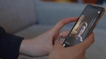 mains de femme tenant un smartphone ayant un appel vidéo video