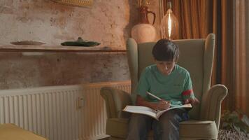 jongen in fauteuil schrijven in werkboek video