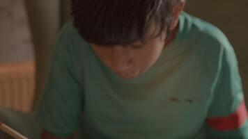 Boy doing maths in armchair video