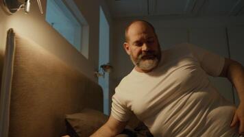 Man waking up sitting on edge of bed video