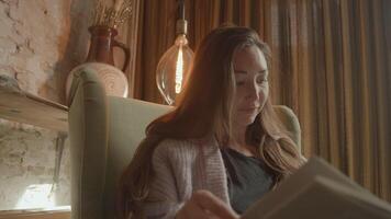 Woman in armchair talking vividly with book on lap video