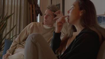 Two women snacking and watching television on sofa video