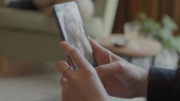 manos de mujer sosteniendo teléfono inteligente con videollamada video