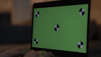 Manos de mujer escribiendo en un portátil con pantalla verde video
