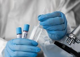 Doctor analyzing blood samples with microscope photo