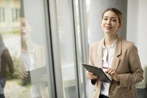 Woman holding a tablet and looking at the camera photo