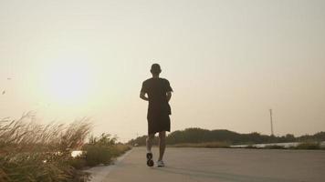 Rückseite des asiatischen Läufers auf der Straße in der Landschaft mit frischer und klarer Luft video