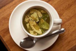 Cup of Coca Tea on Wooden table photo