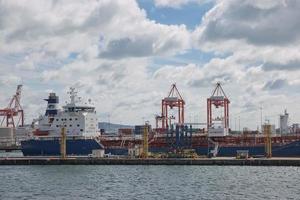 Grandes grúas industriales cargando un buque portacontenedores en el puerto de Dublín en Irlanda