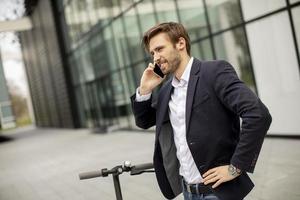 Man taking a business call on a scooter photo