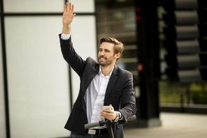 Businessman waving on a scooter photo