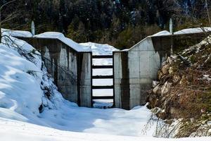 Presa abierta sobre un arroyo y cubierta de nieve. foto