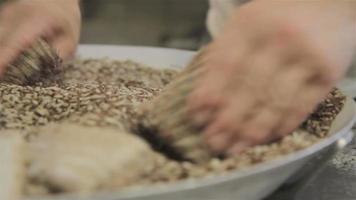 múltiples perspectivas de un chef de panadería enrollando porciones de pan en cereales video