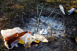 A pile of garbage in the forest park near the campfire site photo