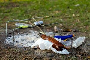 A pile of garbage in the forest park near the campfire site photo