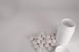 White medical pills and tablets with bottle photo