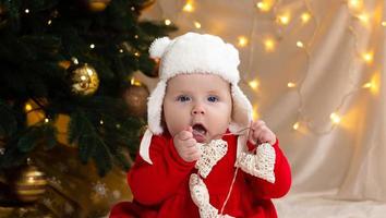 Christmas child looking at the camera and holding a garland with hearts photo