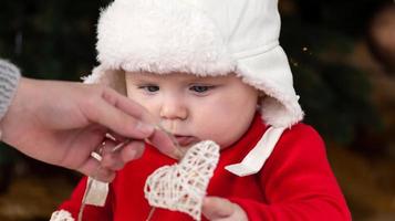 Christmas child looks at a garland with hearts photo