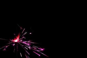 Sparkler in pink and white light on a black background photo