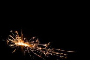 Sparkler in yellow and orange light on a black background photo