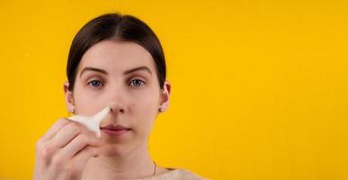 Woman cleaning Her blocked nose with a blue rubber nose pump photo