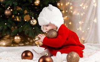 Baby holds Christmas ball photo