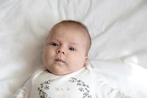 retrato de una niña que yace en la cama foto