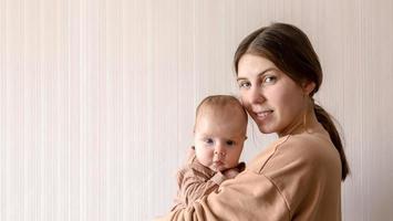 A young mother holds a child girl who is 3 months old photo