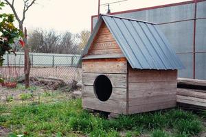 Big wooden doghouse on a house backyard photo