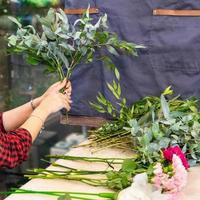 Mujer floristería haciendo ramo de flores en la tienda foto