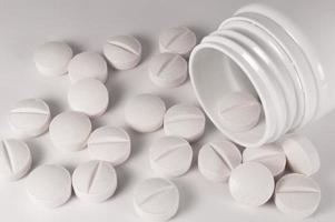 White medical pills and tablets with bottle photo