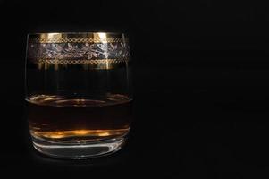 Glass of dark red whiskey brandy or bourbon photo