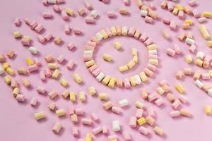 Top view of multi colored marshmallows in the shape of a smiley photo