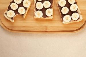 tres tostadas de pan blanco de plátano untadas con mantequilla de chocolate