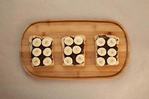 tres tostadas de pan blanco de plátano untadas con mantequilla de chocolate