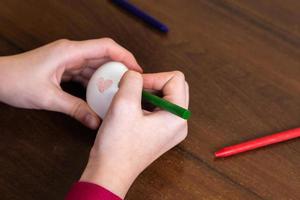 Close-up of woman hands coloring easter eggs with colors and brush photo