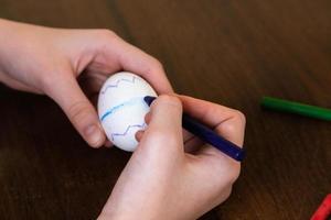 Close-up of woman hands coloring an Easter egg photo