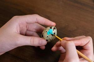 Close-up of woman hands coloring easter eggs with colors and brush photo