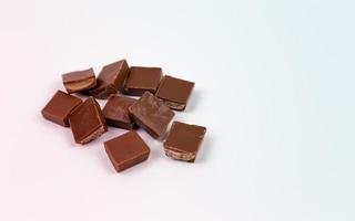 Trozos de barra de chocolate sobre fondo blanco. foto