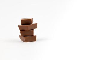Chocolate bar pieces over white background