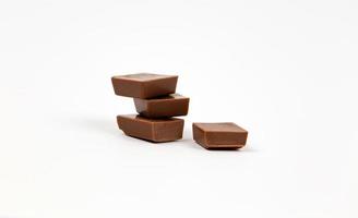 Trozos de barra de chocolate sobre fondo blanco. foto