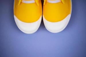 Yellow rubber boots isolated on purple background with copy space photo