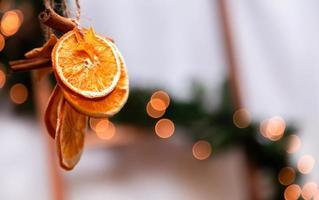 Decoración navideña colgante de naranjas secas, mandarina y estrellas de canela. foto