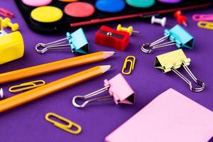 School office supplies stationery on a purple background desk Back to school concept photo