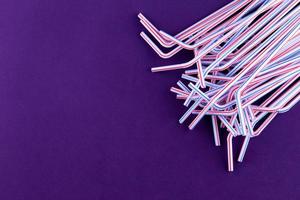 Coctail plastic tubes on blue purple background photo