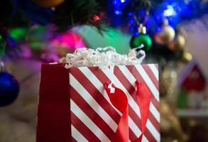 Paquete de regalo de rayas rojas y blancas sobre un fondo de navidad